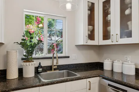 a kitchen with granite countertop stainless steel appliances a sink and cabinets