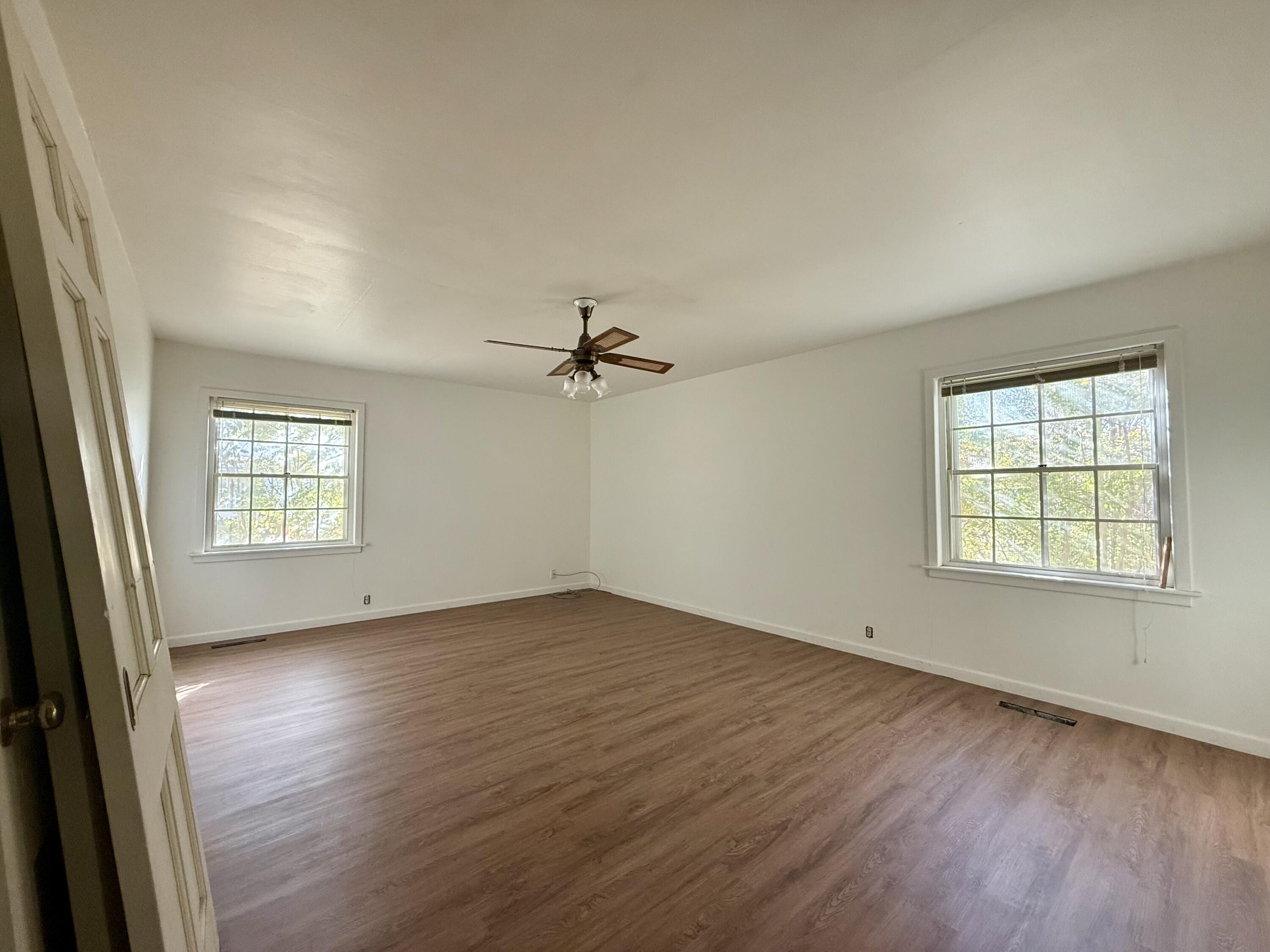 321 10th Street Memphis, TX 79245 - Photo 24 of 33 an empty room with wooden floor ceiling fan and windows