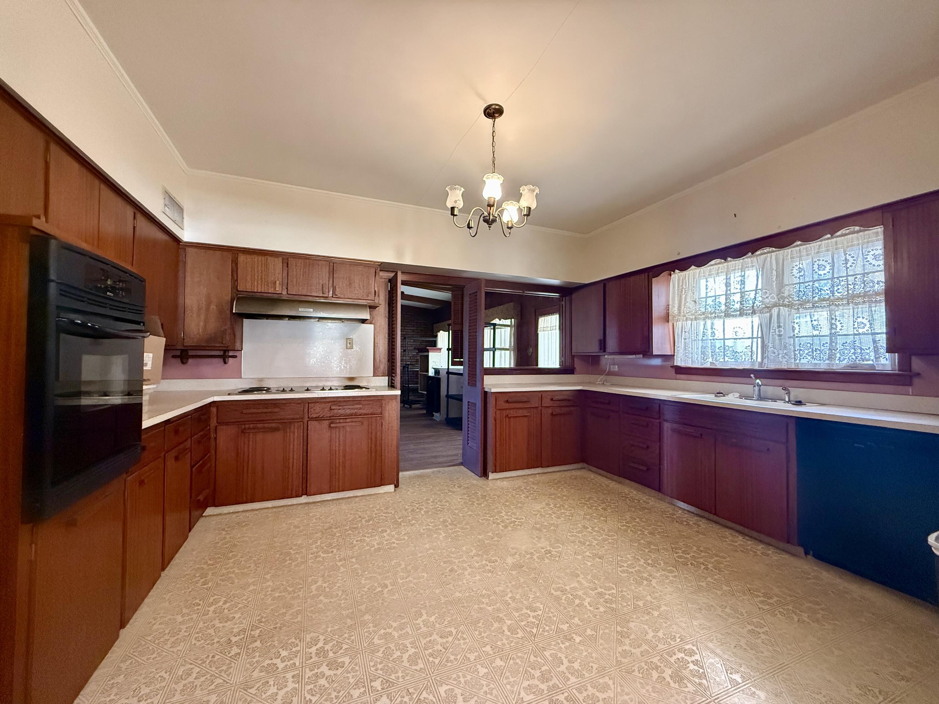321 10th Street Memphis, TX 79245 - Photo 10 of 33 a kitchen with stainless steel appliances granite countertop a refrigerator a sink dishwasher a stove top oven and a dining table with wooden floor