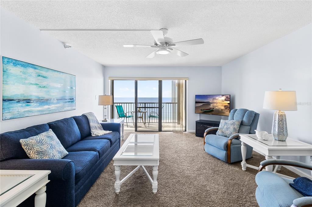 15000 Gulf Boulevard, Unit 605 Madeira Beach, FL 33708 - Photo 14 of 54 a living room with furniture a large window and a flat screen tv