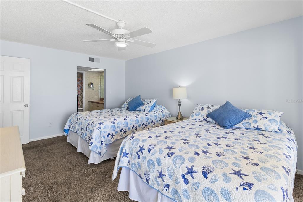 15000 Gulf Boulevard, Unit 605 Madeira Beach, FL 33708 - Photo 20 of 54 a bedroom with two beds and a chandelier