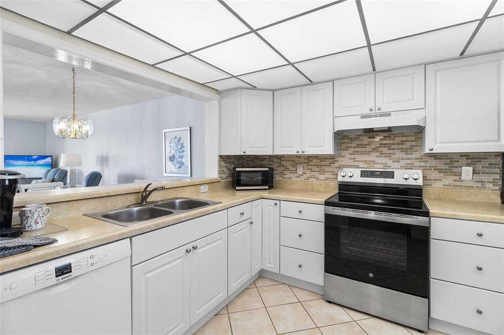 15000 Gulf Boulevard, Unit 605 Madeira Beach, FL 33708 - Photo 4 of 54 a kitchen with cabinets appliances a sink and a counter top