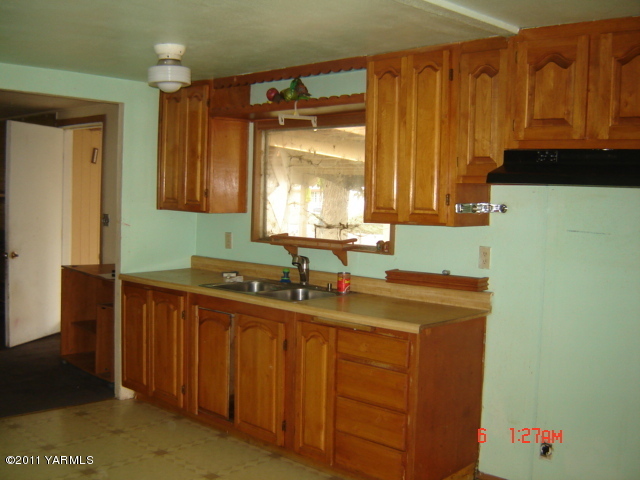 411 Swan Road Sunnyside, WA 98944 - Photo 8 of 14 a kitchen with a sink a window and cabinets