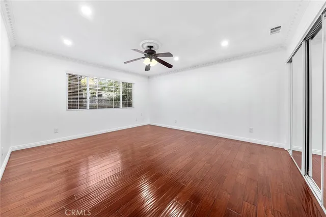 a view of a lake with a large tree and wooden fence
