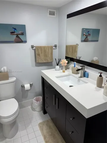 a bathroom with a sink mirror vanity and toilet