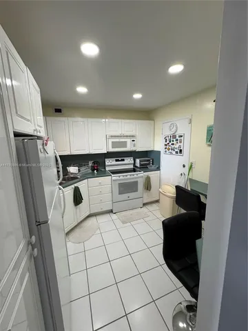 a kitchen with stainless steel appliances granite countertop a refrigerator sink and stove