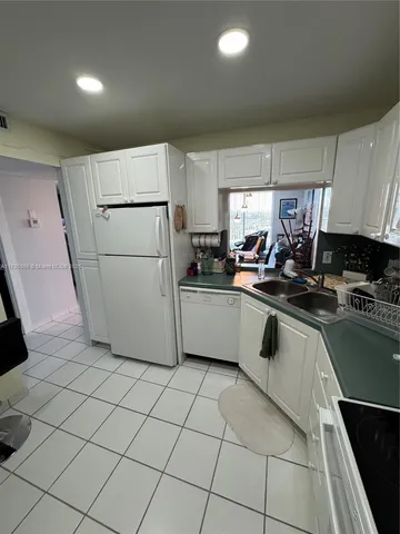 a kitchen with a sink a refrigerator and cabinets