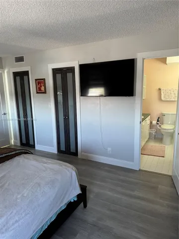 a bedroom with a bed and a flat screen tv