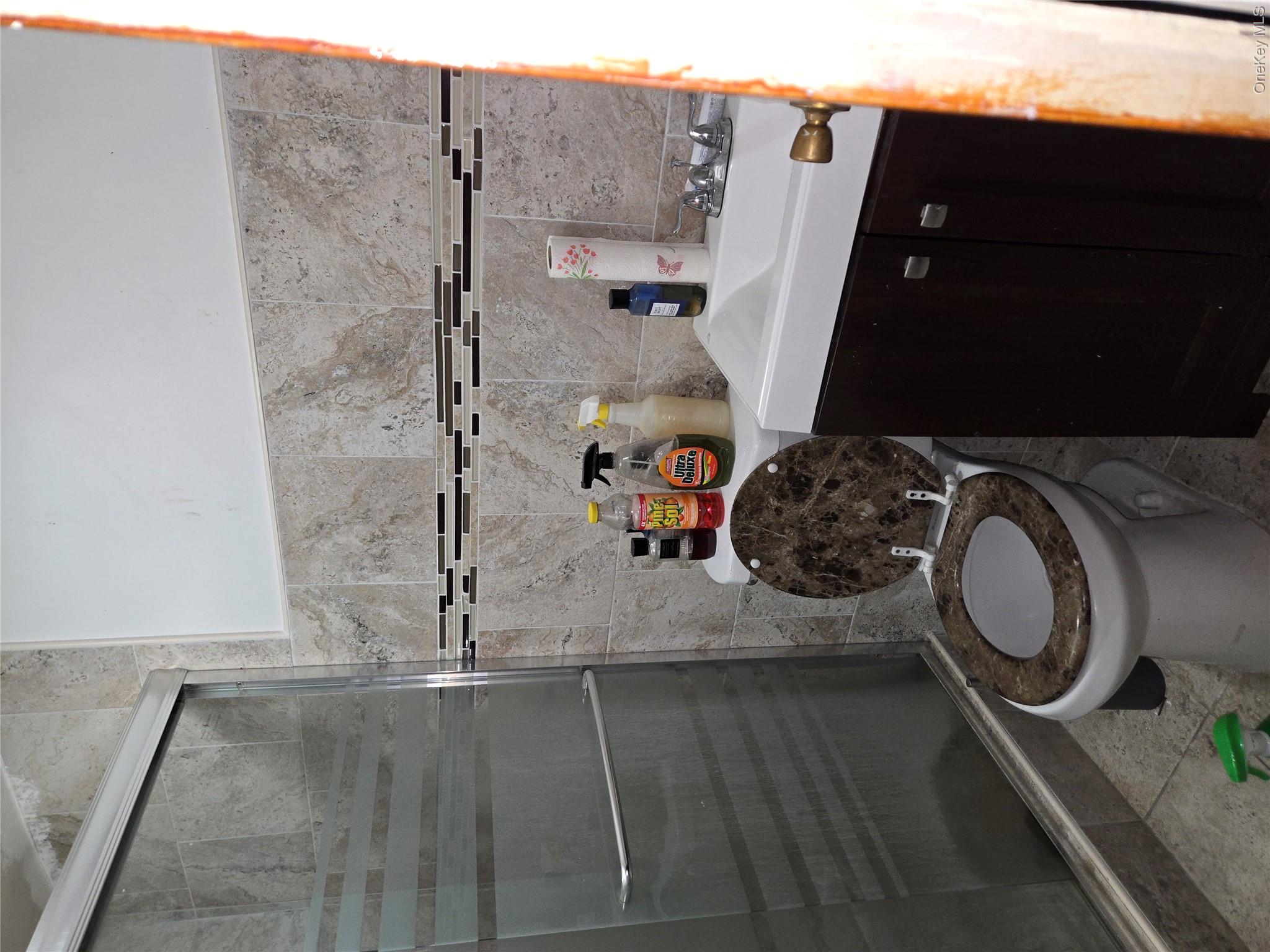 343 Rutland Road Brooklyn, NY 11225 - Photo 12 of 17 Full bath featuring vanity, a shower stall, tile walls, and tile patterned floors