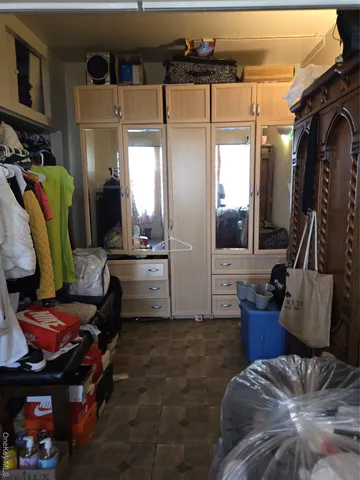 a living room with furniture a flat screen tv and a refrigerator