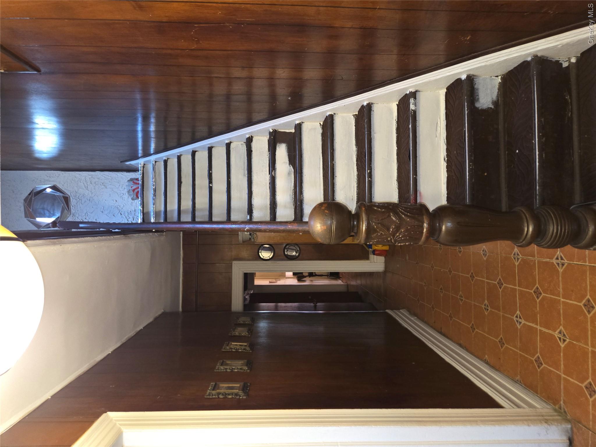 343 Rutland Road Brooklyn, NY 11225 - Photo 9 of 17 Staircase with wood walls and tile patterned floors