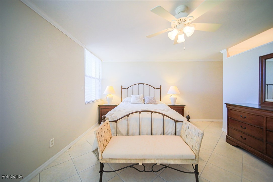 5959 Winkler Road, Unit 206 Fort Myers, FL 33919 - Photo 12 of 50 a white bed sitting in a bedroom next to a window with a chandelier