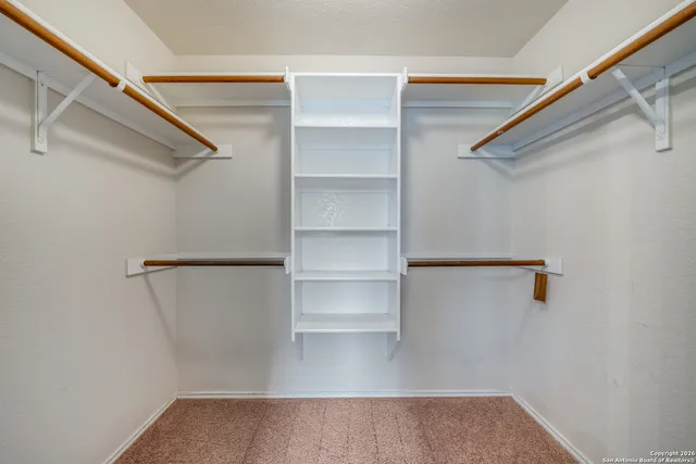 a view of walk in closet with empty racks
