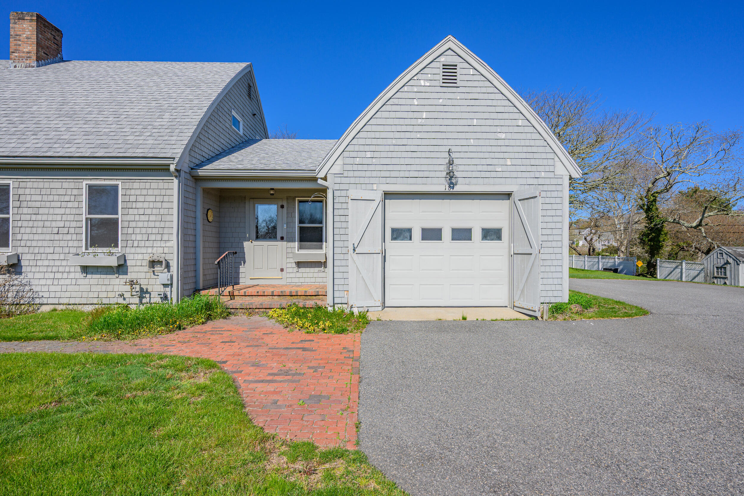 181 Elliott Road Centerville, MA 02632 - Photo 45 of 60 a front view of a house with a yard and garage