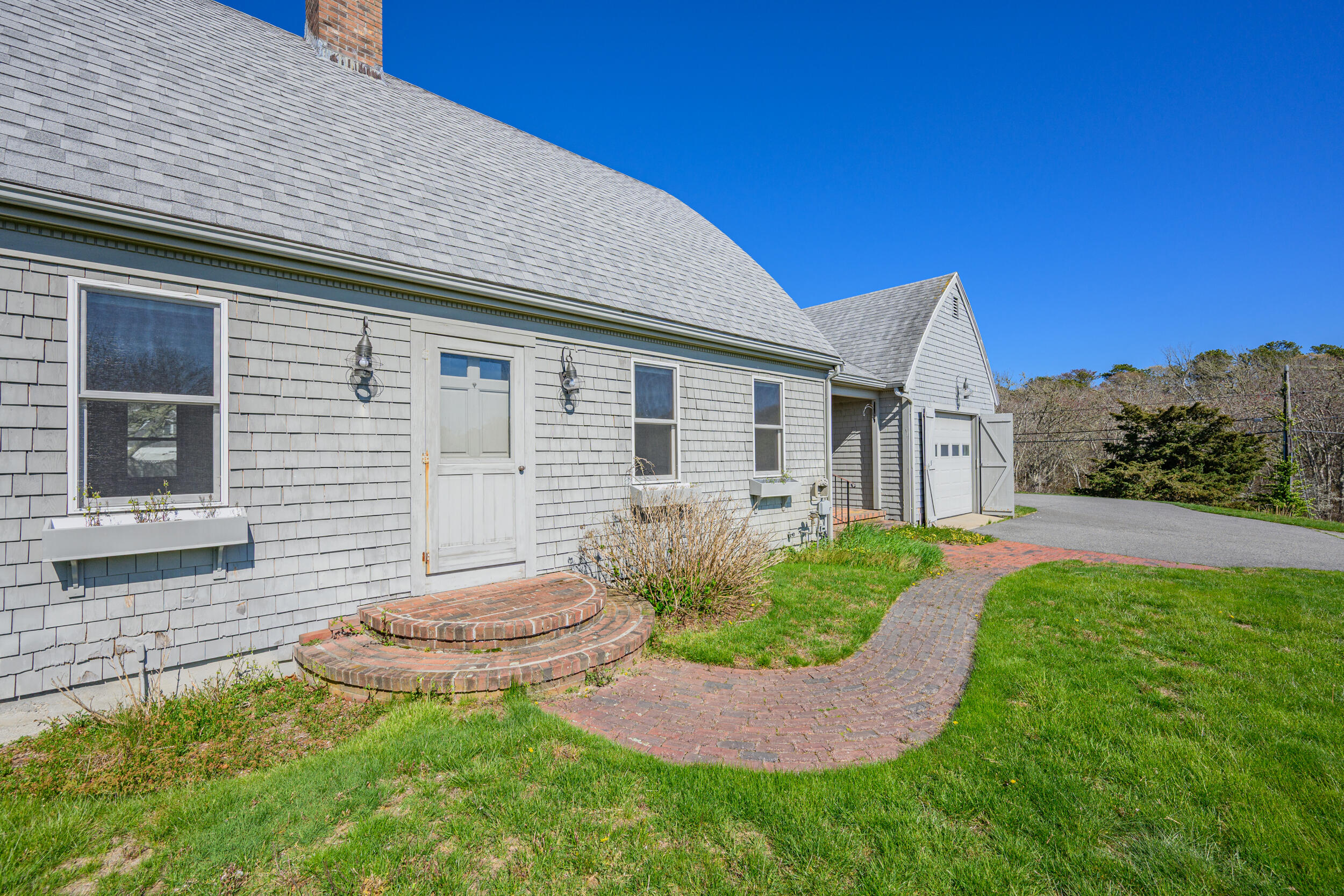 181 Elliott Road Centerville, MA 02632 - Photo 57 of 60 a view of a backyard with table and chairs and potted plants