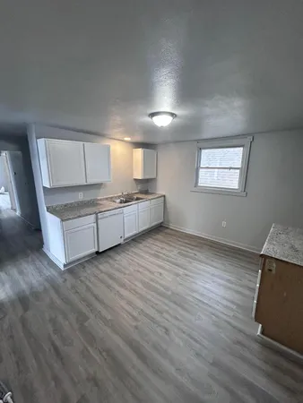 an empty room with wooden floor and window