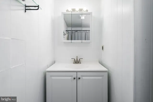 a large white kitchen with sink and refrigerator
