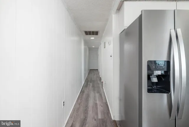 a kitchen with stainless steel appliances a sink a stove a refrigerator cabinets and a dining table