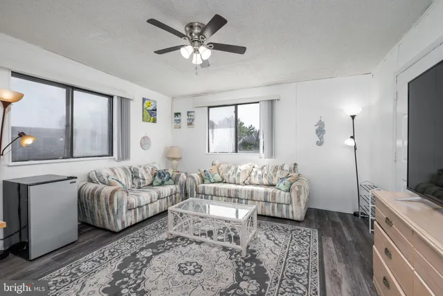 a living room with lots of furniture and view of kitchen
