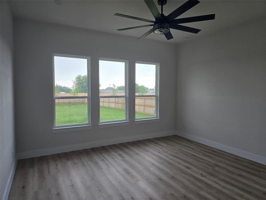 808 N Avenue East Springtown, TX 76082 - Photo 10 of 21 wooden floor in an empty room with a window