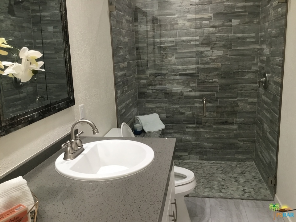 1111 East Ramon Road, Unit 8 Palm Springs, CA 92264 - Photo 16 of 36 a bathroom with a sink a toilet and mirror