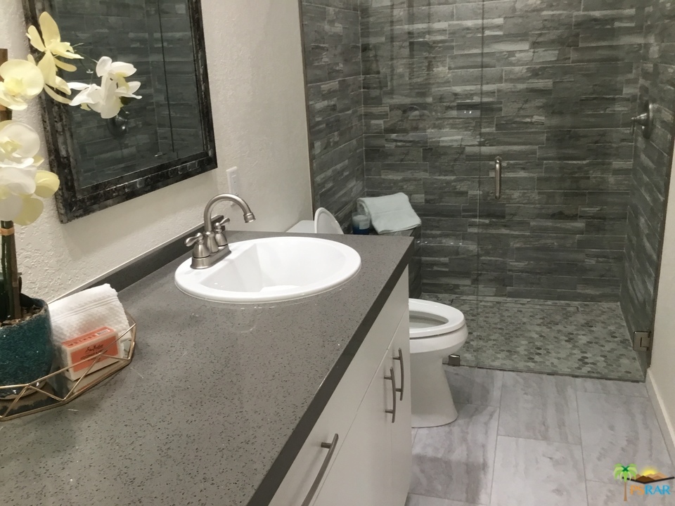 1111 East Ramon Road, Unit 8 Palm Springs, CA 92264 - Photo 17 of 36 a bathroom with a toilet a sink and mirror