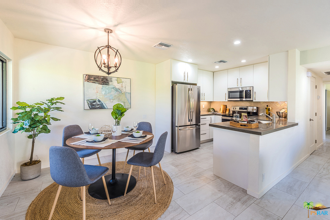 1111 East Ramon Road, Unit 8 Palm Springs, CA 92264 - Photo 4 of 36 a kitchen with refrigerator and chairs