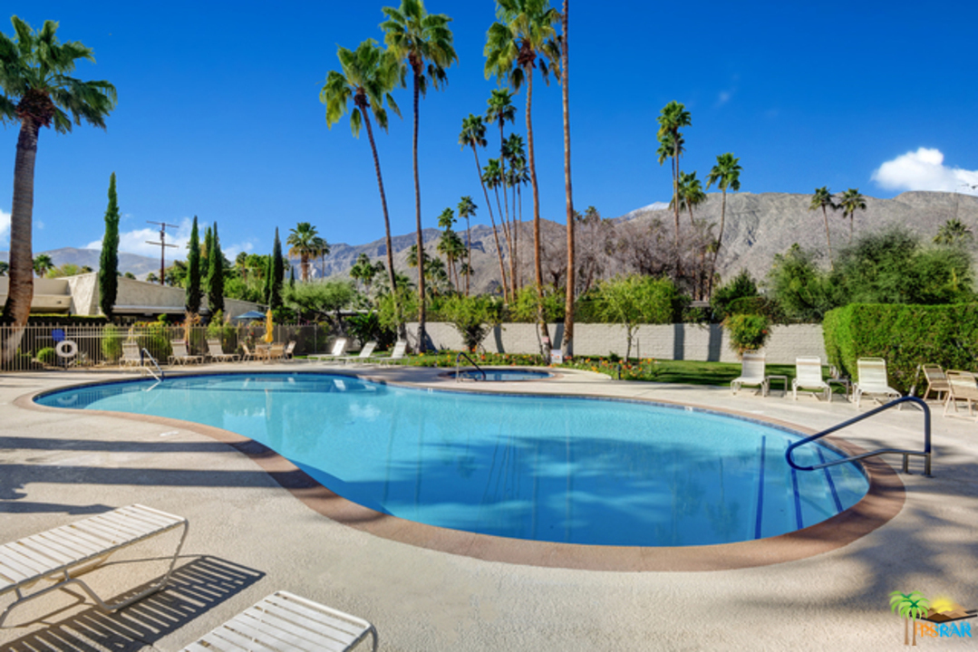 1111 East Ramon Road, Unit 8 Palm Springs, CA 92264 - Photo 34 of 36 a view of a swimming pool with a yard and plants