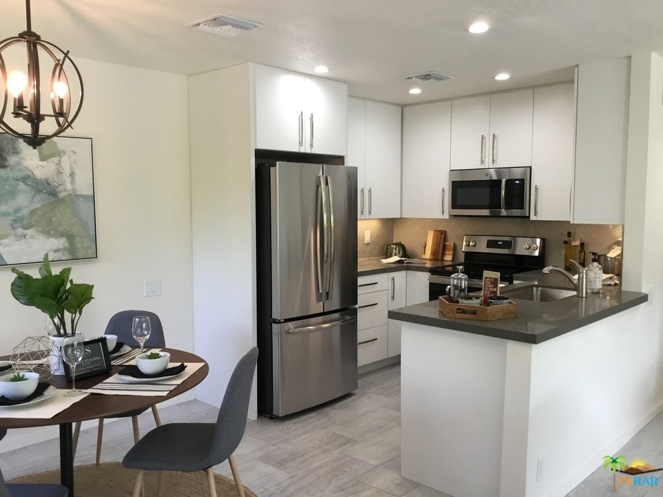 1111 East Ramon Road, Unit 8 Palm Springs, CA 92264 - Photo 6 of 36 a kitchen with stainless steel appliances granite countertop a sink refrigerator and microwave