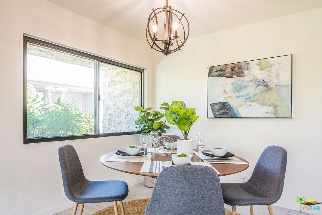 1111 East Ramon Road, Unit 8 Palm Springs, CA 92264 - Photo 9 of 36 a dining room with furniture a large window and a chandelier