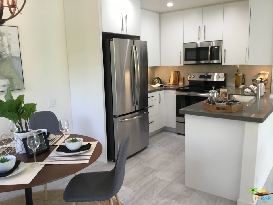 1111 East Ramon Road, Unit 8 Palm Springs, CA 92264 - Photo 10 of 36 a kitchen with stainless steel appliances granite countertop a refrigerator stove top oven a sink and dishwasher