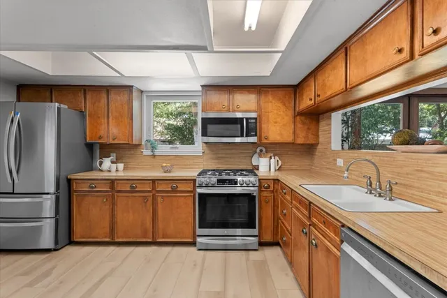 a kitchen with stainless steel appliances granite countertop a sink stove and refrigerator