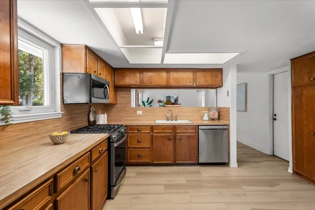 a kitchen with stainless steel appliances granite countertop a sink and a stove