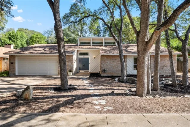 a view of a house with a door and a tree