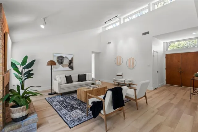 a living room with furniture potted plant and a table