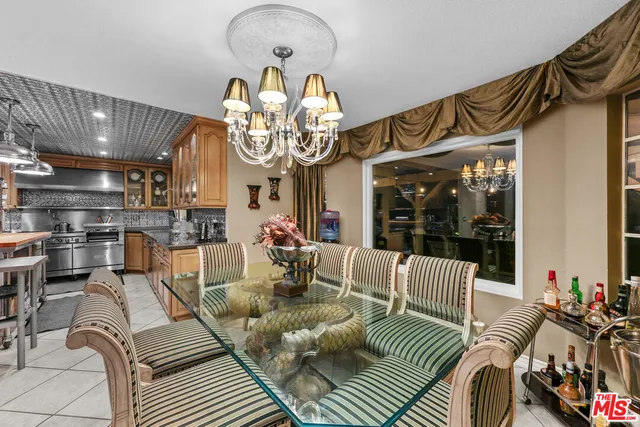 a living room with furniture a chandelier and a floor to ceiling window