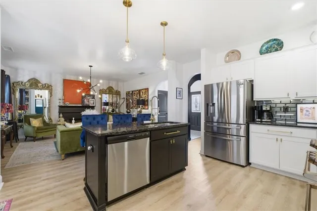 a kitchen with stainless steel appliances granite countertop a refrigerator a stove and a sink