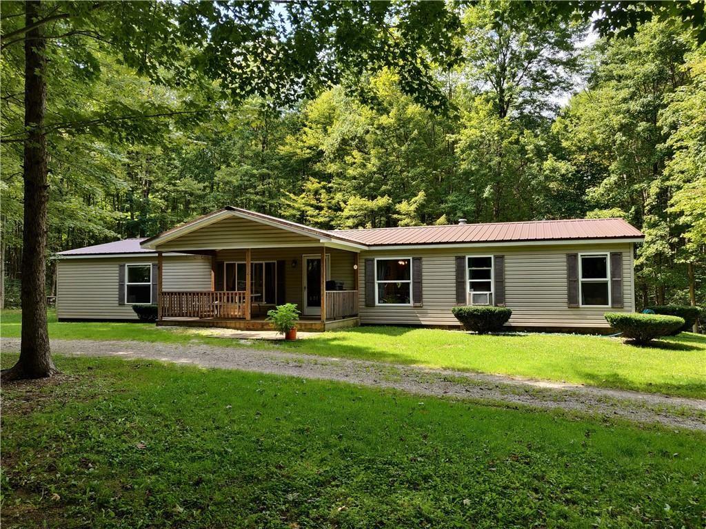 a front view of a house with a yard and trees