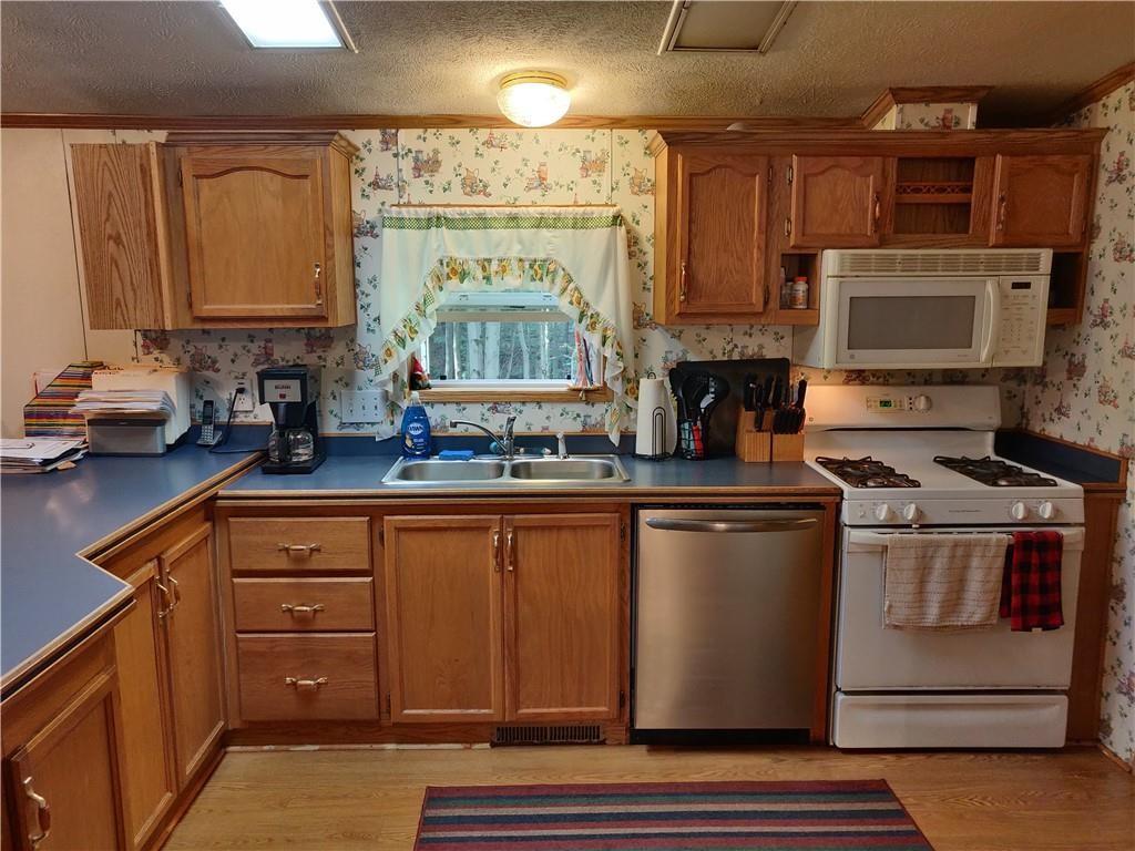6173 Philadelphia Road Springboro, PA 16435 - Photo 10 of 25 a kitchen with stainless steel appliances granite countertop a stove a sink and a microwave