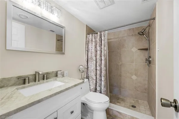 a bathroom with a granite countertop sink toilet and shower