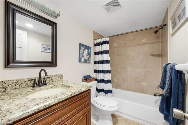 a bathroom with a granite countertop sink toilet mirror and shower