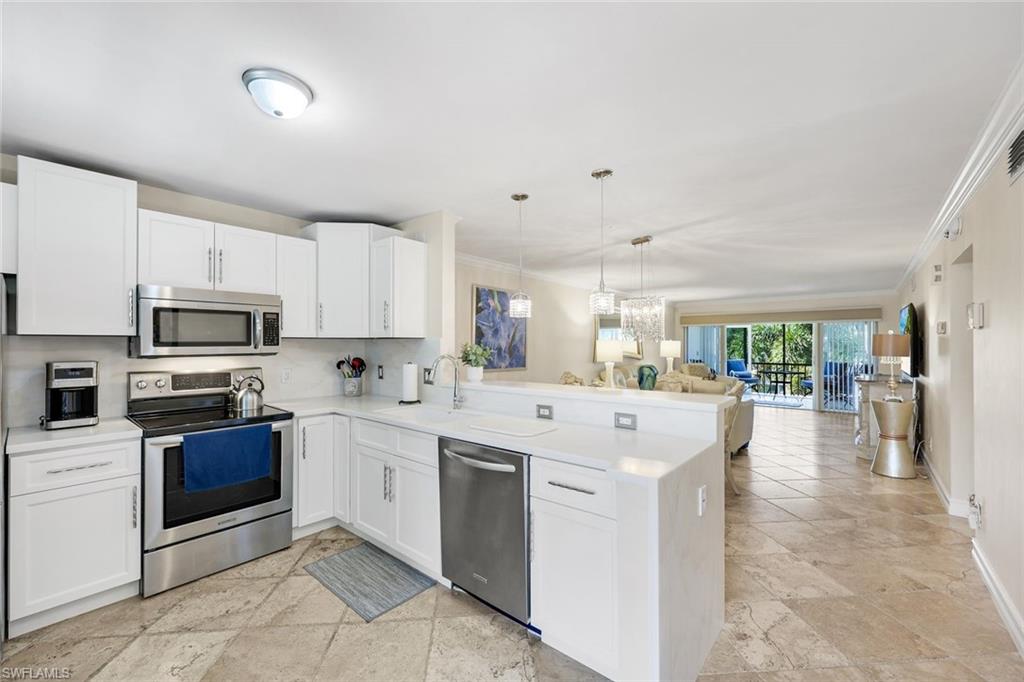 4200 Belair Lane, Unit 316 Naples, FL 34103 - Photo 2 of 18 a kitchen with stainless steel appliances kitchen island granite countertop a stove and white cabinets