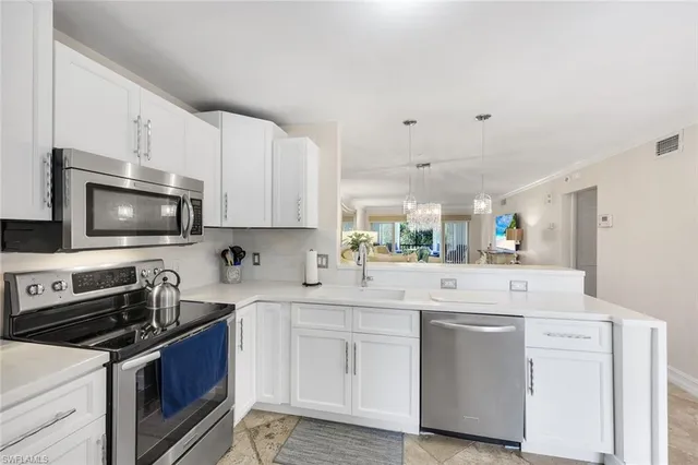 a kitchen with white cabinets appliances and sink