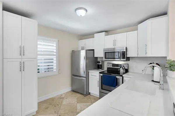 a kitchen with stainless steel appliances a refrigerator a stove a microwave and cabinets