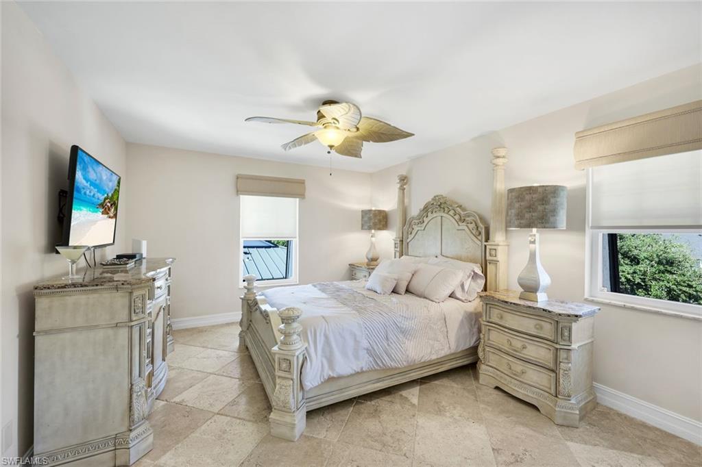 4200 Belair Lane, Unit 316 Naples, FL 34103 - Photo 10 of 18 a bedroom with a bed and a chandelier