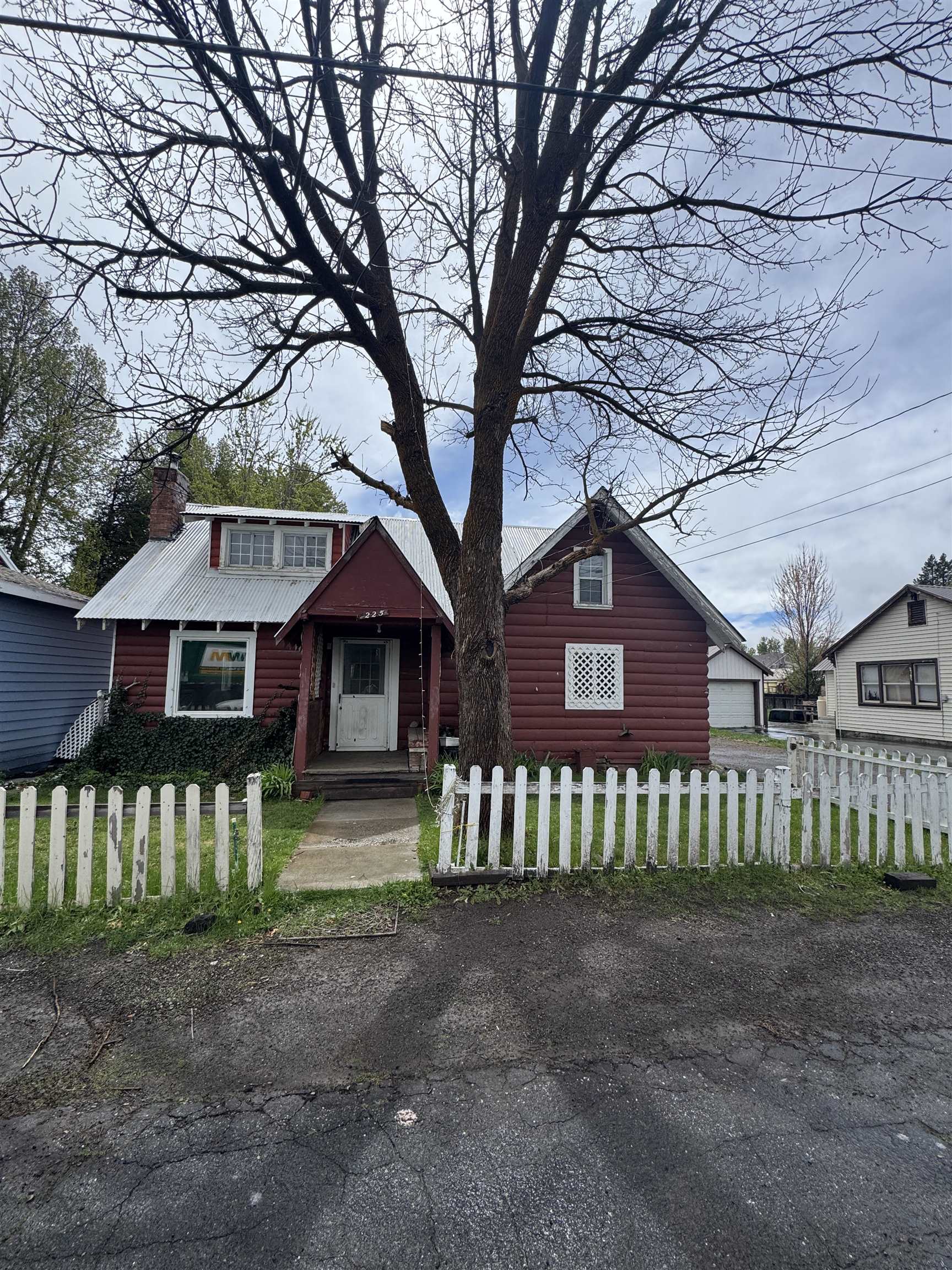 225 Lassen Street Chester, CA 96020 - Photo 1 of 23 a small barn in front of a yard with wooden fence and a large tree