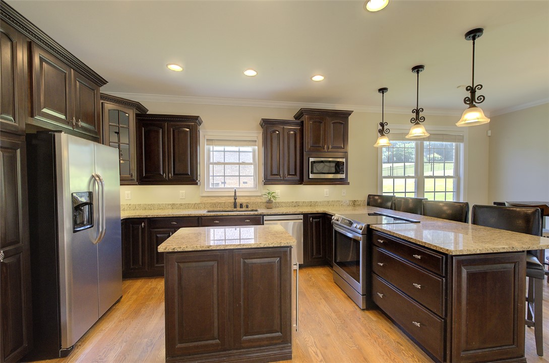 100 Turnberry Road Anderson, SC 29621 - Photo 11 of 41 A well-appointed kitchen features rich cabinetry, granite countertops, and modern stainless steel appliances.