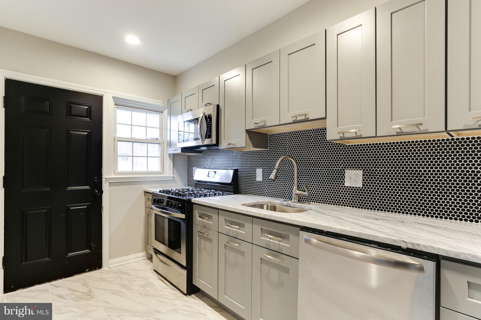 1425 Kitmore Road Baltimore, MD 21239 - Photo 4 of 23 a kitchen with stainless steel appliances granite countertop a stove a sink and a microwave