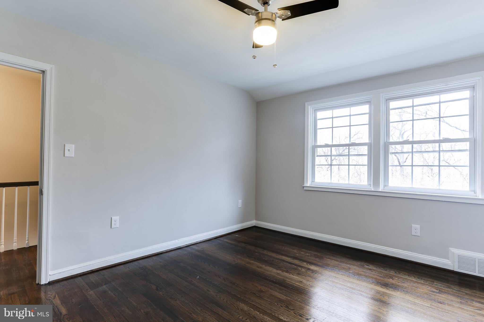 1425 Kitmore Road Baltimore, MD 21239 - Photo 9 of 23 an empty room with wooden floor and windows