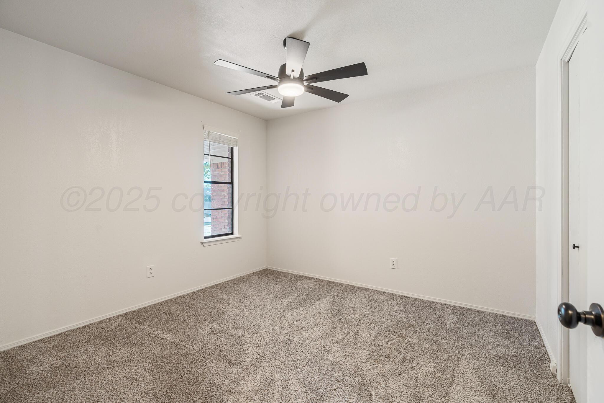 6212 Rutgers Street Amarillo, TX 79109 - Photo 18 of 26 an empty room with chandelier fan and windows